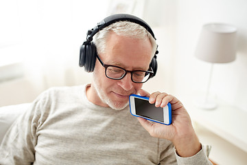 Image showing happy senior man with smartphone and headphones