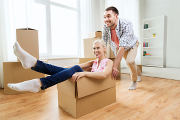 Image showing couple with cardboard boxes having fun at new home