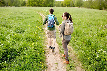 Image showing happy couple with backpacks hiking outdoors