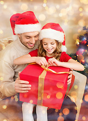 Image showing smiling father and daughter opening gift box