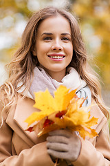Image showing beautiful woman with maple leaves in autumn park