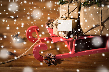 Image showing close up of christmas gifts with note on sleigh