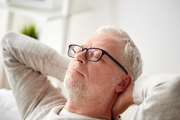 Image showing senior man in glasses relaxing on sofa