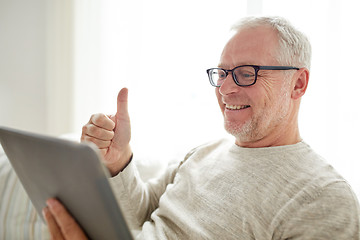 Image showing senior man having video call on tablet pc at home