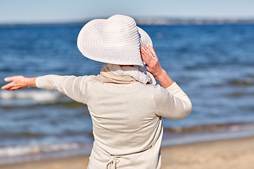 Image showing happy senior woman in sun hat on summer beach