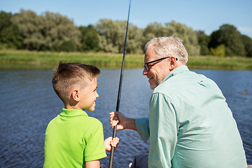 Image showing grandfather and grandson fishing on river berth