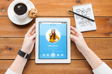 Image showing close up of woman with tablet pc on wooden table