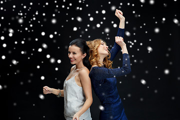 Image showing happy young women dancing over snow
