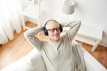 Image showing happy man in headphones listening to music at home