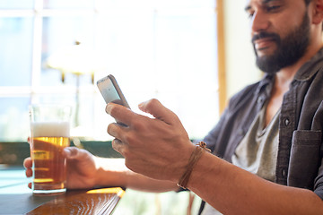 Image showing close up of man with smartphone and beer at pub