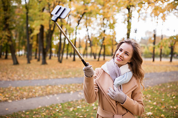 Image showing woman taking selfie by smartphone in autumn park