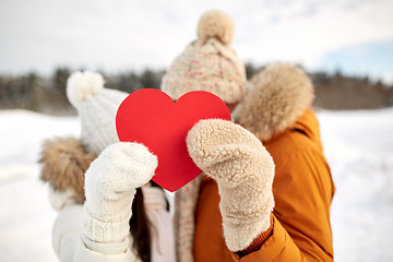 Image showing happy couple with red heart over winter landscape