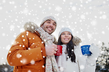 Image showing happy couple with tea cups over winter landscape