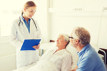 Image showing senior woman and doctor with clipboard at hospital