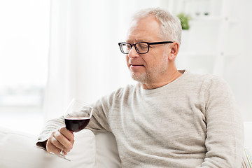 Image showing senior man drinking red wine from glass at home