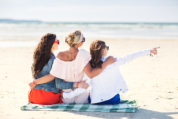 Image showing group of young women hugging on beach