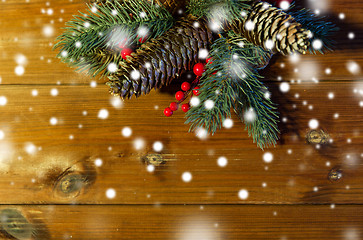 Image showing close up of fir branch with cones on wooden table