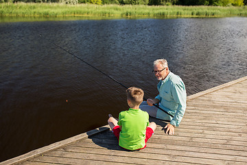 Image showing grandfather and grandson fishing on river berth