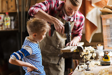 Image showing father and son with drill working at workshop