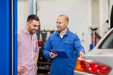 Image showing auto mechanic with clipboard and man at car shop