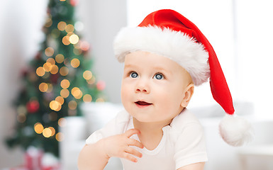 Image showing baby boy in christmas santa hat over blue lights