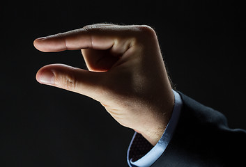 Image showing close up of businessman hand showing small size