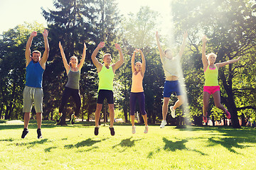 Image showing group of happy friends jumping high outdoors