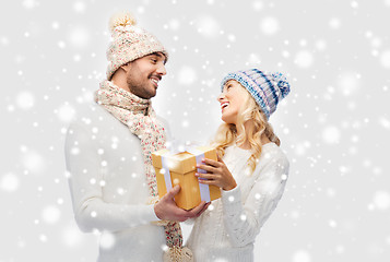 Image showing smiling couple in winter clothes with gift box