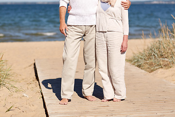 Image showing close up of senior couple hugging on summer beach