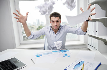 Image showing angry businessman throwing papers in office