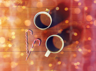 Image showing christmas candy canes and cups on wooden table