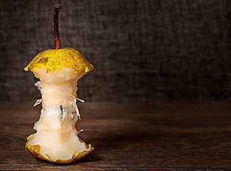 Image showing Stub of pear on wooden table