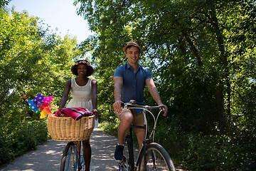 Image showing Young multiethnic couple having a bike ride in nature