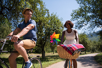 Image showing Young multiethnic couple having a bike ride in nature