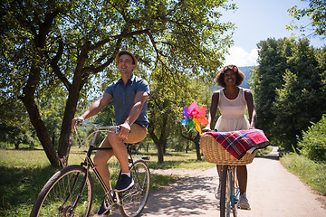 Image showing Young multiethnic couple having a bike ride in nature