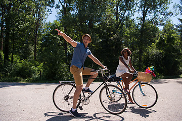 Image showing Young multiethnic couple having a bike ride in nature