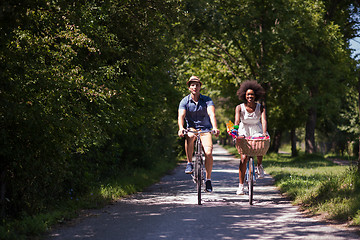 Image showing Young multiethnic couple having a bike ride in nature