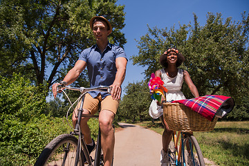 Image showing Young multiethnic couple having a bike ride in nature