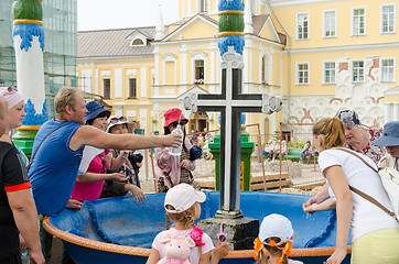 Image showing Sergiev Posad - August 10, 2015: Tourists are gaining the holy water in the passage of the bowl with a cross in Svvyato Trinity St. Sergius Lavra