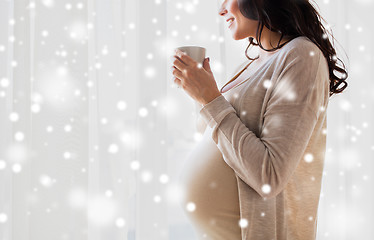 Image showing close up of pregnant woman with tea cup at window