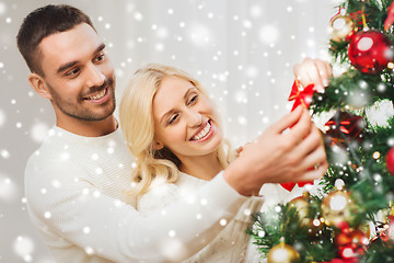 Image showing happy couple decorating christmas tree at home