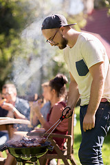 Image showing man cooking meat on barbecue grill at summer party