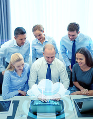 Image showing smiling business people with laptop in office