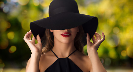 Image showing beautiful woman in black hat over dark background