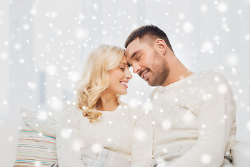 Image showing happy couple covered with plaid on sofa at home