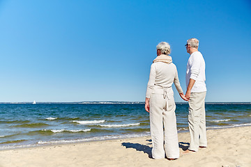 Image showing happy senior couple holding hands summer beach