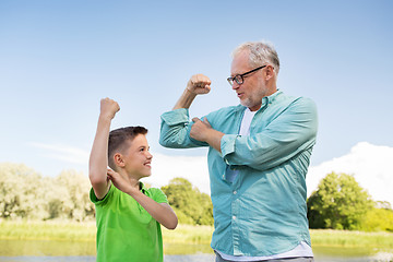 Image showing happy grandfather and grandson showing muscles