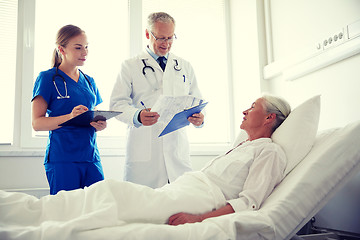 Image showing doctor and nurse visiting senior woman at hospital