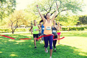 Image showing happy young female runner winning on race finish