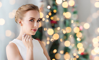 Image showing woman with diamond jewelry over christmas lights